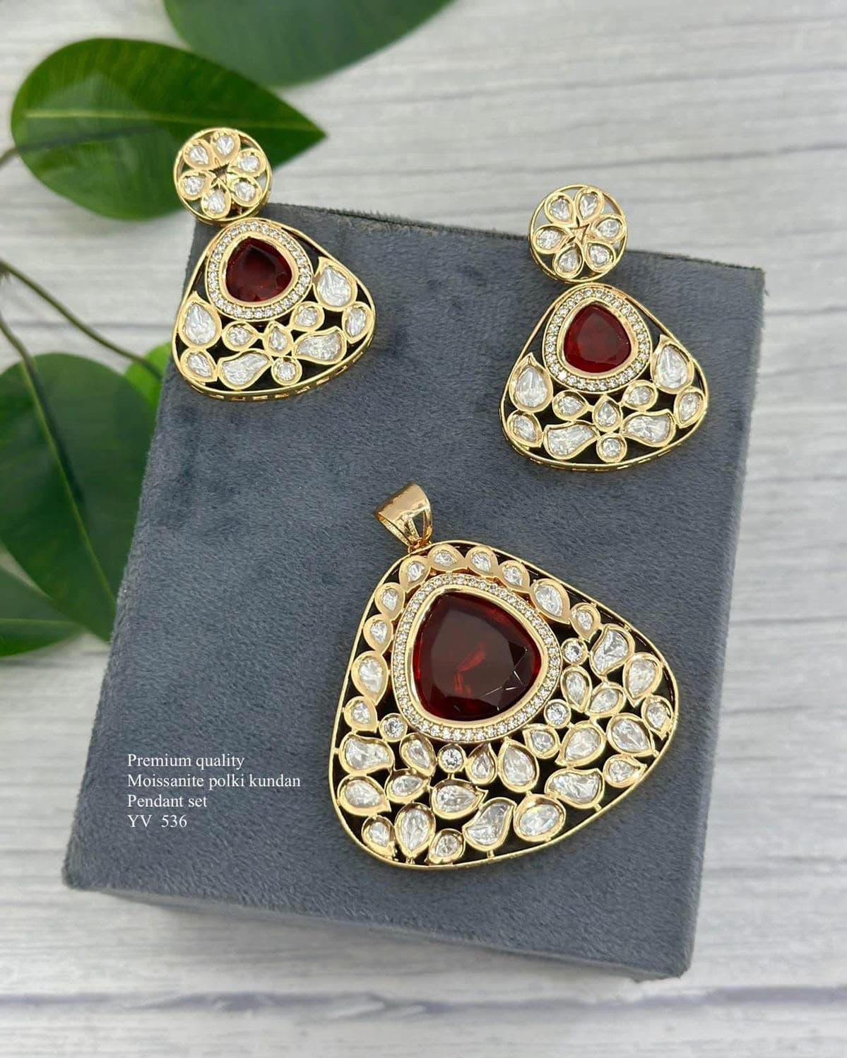 Garnet Polki — A deep red teardrop above a field of uncut stones, cut wide at the base.
