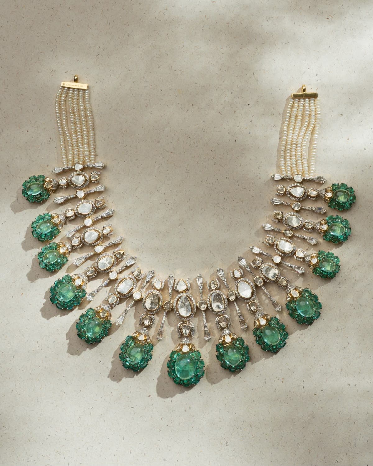 Panna — Polki fans out from the neck in tiers, each ending in a green cabochon ringed in green, on five strands of seed pearls.