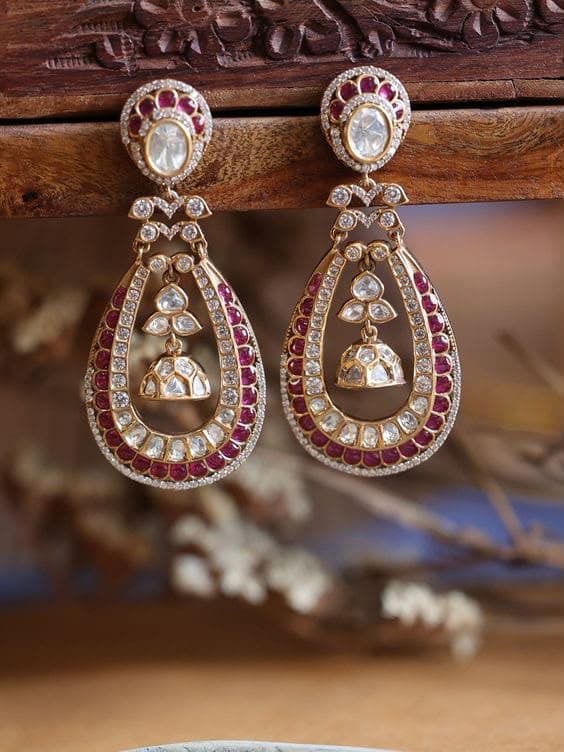 Ruby Chandbali — A crescent outlined in red, with a small jhumka swinging inside the opening.